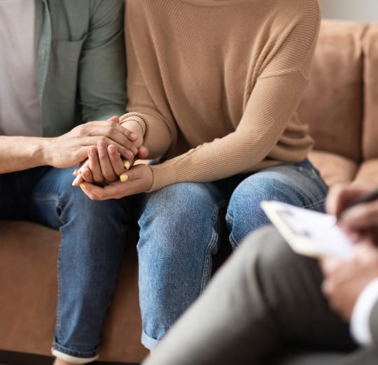 Couple talking at session with male therapist